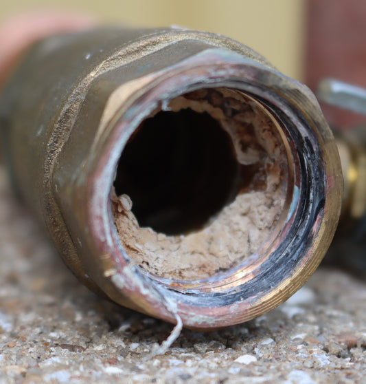 Heavy mineral scale buildup inside a water fitting can reduce the available opening and restrict water flow over time